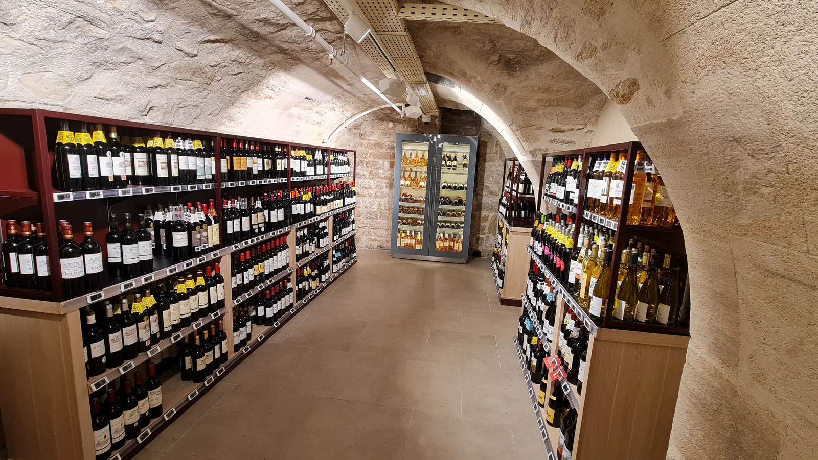 Cave à vin voûtée aménagée avec éclairage et rayonnages