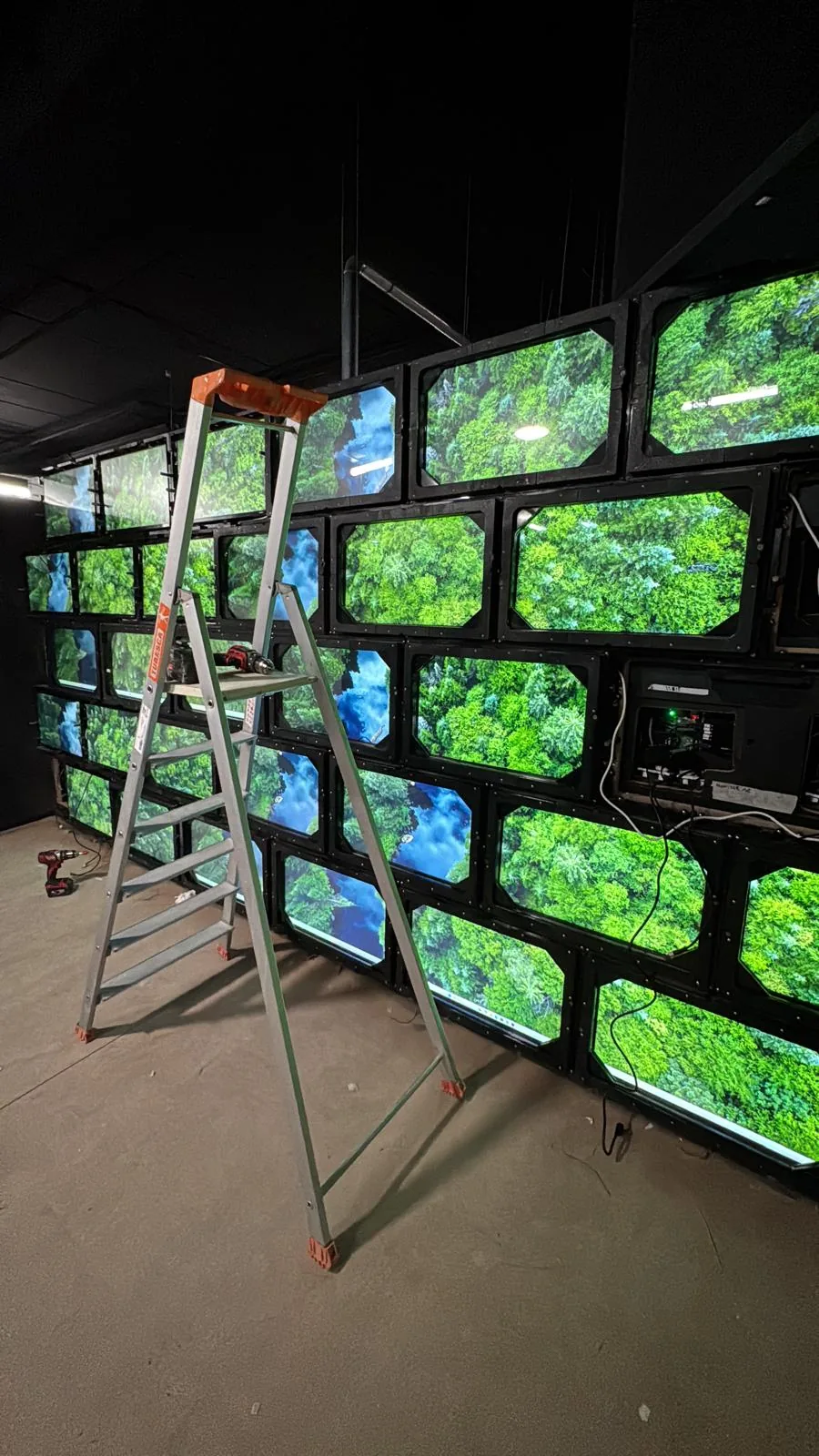 Mur d'écrans en cours de raccordement dans une salle de jeu immersive